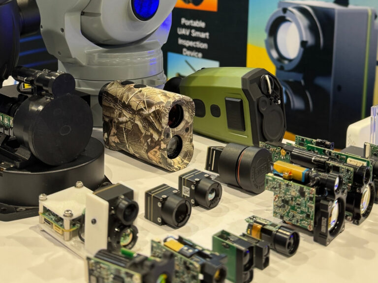 Sunflaser team members engaging with visitors at an international technology expo, showcasing laser rangefinder modules and electro-optical systems.