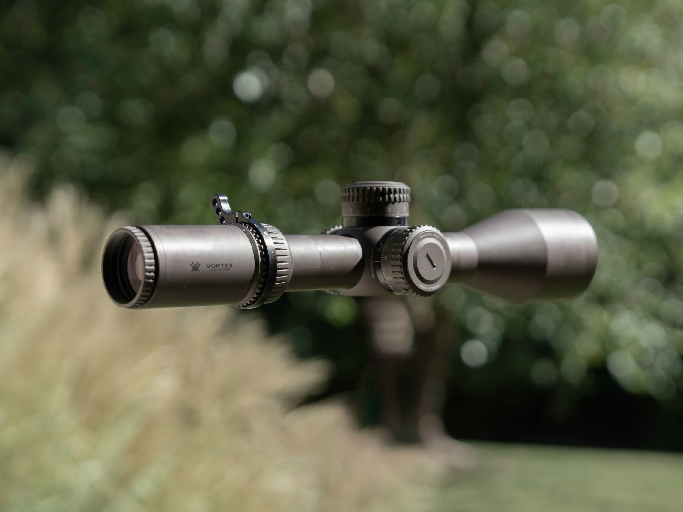 An outdoorsman carefully using a high-quality laser rangefinder to measure the distance to a distant ridge, demonstrating its practical application in hunting or hiking.
